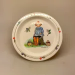 Elsa Beskow service Putte i blåbærskoven flad tallerken, putte, blåbærskoven, Elsa Beskow, astrid lindgren, sverige, svensk, børnebøger, tegner, eventyr, historier, service, til børn, smukke, tegninger, illustrationer, børneservice, tallerken, skål, krus, bestik, dåbsgave, barnedåb, nyfødt, barselsgave, emil, ida, småland, lønneberg, gave, gaveide, nostalgisk, biti, ribe