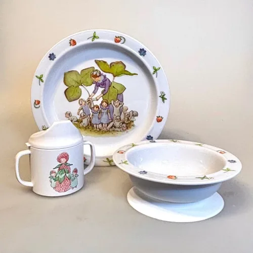 Blomsterbørn - en serie i rød/gul/blå. Den flade tallerken med blåt motiv, den dybe med rødt og kruset med gult og rødt., Elsa Beskow Dyb Tallerken - Blomsterbørn, Elsa Beskow Flad Tallerken - Blomsterbørn, Elsa Beskow Krus med Låg - Blomsterbørn, blomsterbarnen, blomsterfesten, blomsternes bog, astrid lindgren, billedbøger, eventyr, illustrationer, tegninger, tudkop, kop, krus, lågkrus, baby, babyshower, barnedåb, dåbsgave, barselsgave, svensk, nostalgisk, service, til børn, drikke, tud, biti, ribe