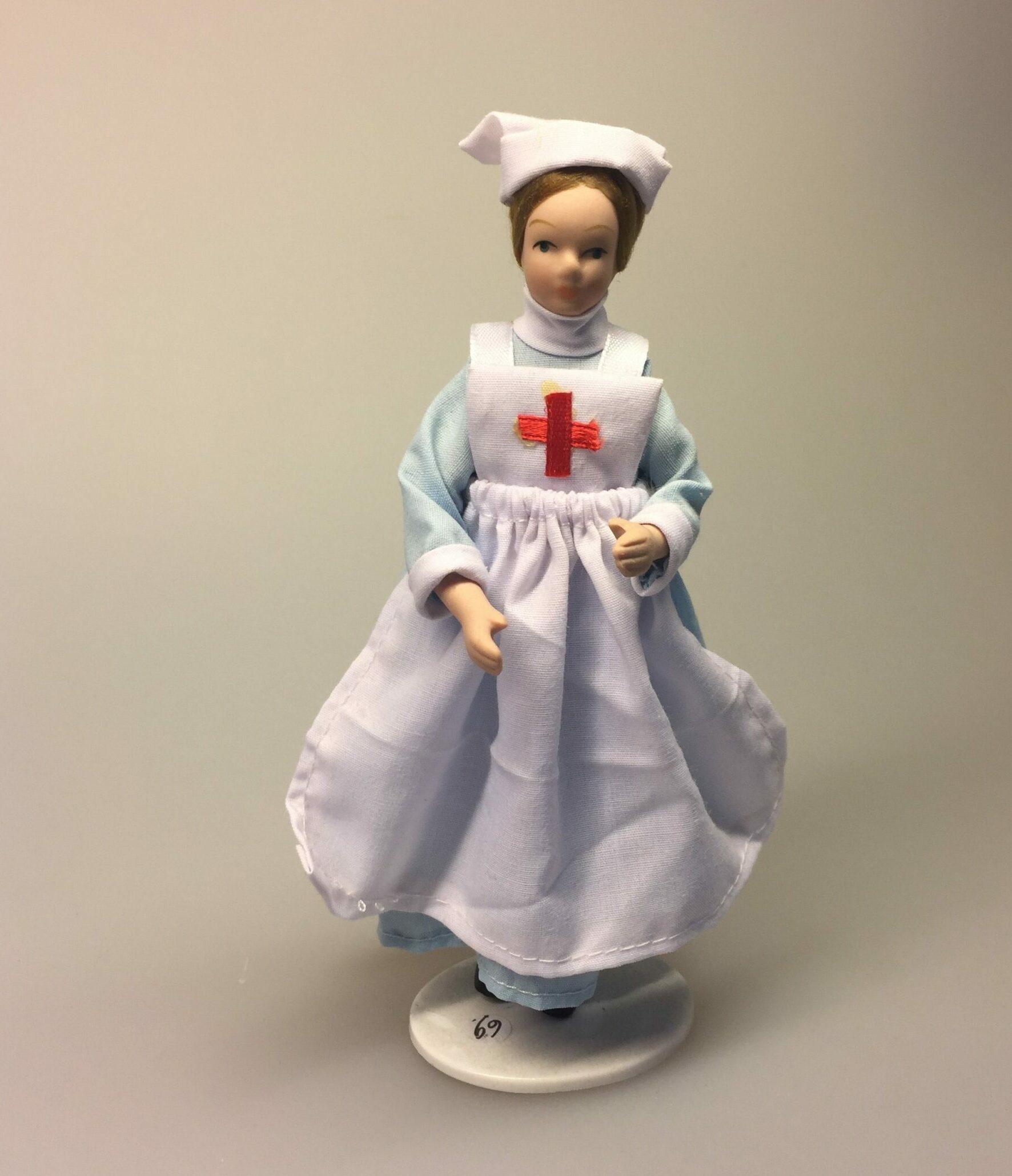 Dukke sygeplejerske med lyseblå kjole og forklæde