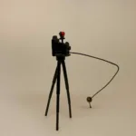 Miniature Kamera på Fod, gammeldags, selvudløser, fotograf, fotgrafering, professionel, symbolsk, sangskjuler, selfie, selfies, billeder, kamera, kamerastativ, miniature, dukkehus, dukkehusting, dukkehustilbehør, ting til, tilbehør, dukkemøbler, sætterkasse, sættekasse, sættekasseting, ting til sætterkasse, amagerhylde, kigkasse, stilleben, sjov, gavekort, biti, ribe