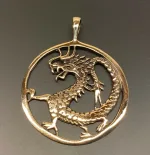 Vikingevedhæng i bronze - Drage i cirkel, drage, magisk, magi, fabeldyr, eventyrligt, eventyr, amulet, beskyttelse, mytologi, vikingesmykker, vikingesmykke, ting med drager, drage, puf, styrke, beskyttelse, held, skjold, museumssmykker, museumssmykke, museums, kopismykke, vikingekopi, vikingefund, fund, opgravninger, gamle, guder, nordiske, aser, asatro, gamle guder, ribe, vadehavet, sort sol, biti, ribe, nationalpark, speciel, flot, bronze, bronzesmykke, bronzesmykker, bronze vedhæng,