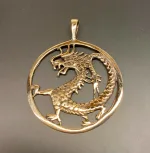 Vikingevedhæng i bronze - Drage i cirkel, drage, magisk, magi, fabeldyr, eventyrligt, eventyr, amulet, beskyttelse, mytologi, vikingesmykker, vikingesmykke, ting med drager, drage, puf, styrke, beskyttelse, held, skjold, museumssmykker, museumssmykke, museums, kopismykke, vikingekopi, vikingefund, fund, opgravninger, gamle, guder, nordiske, aser, asatro, gamle guder, ribe, vadehavet, sort sol, biti, ribe, nationalpark, speciel, flot, bronze, bronzesmykke, bronzesmykker, bronze vedhæng,