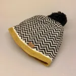 Strikket Hue uld med foer - Beanie Zig-Zag med kvast, beanie, kvast, pompon, zigzag, zig-zag, mønster, grafisk, kontrast, kant, okkergul, okkerfarvet, varmgul, gul, sort-hvid, mønsyerstrik, ulden, uldhue, hue, beaniehue, uldhue, hat, håndstrikket, strik, dansk, design, marianne østergaard, ribe, marianne isager, biti, torvet, ribe domkirke, vadehavet, sort sol, stære, nationalpark, marsken, vinterhue, gaveide, færdigstrikket, smart, hipster, strik, uld, merino, merinould