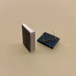 Miniature Bøger og læsebriller, bog, bøger, læsehest, miniature, miniaturer, dukkehusting, bibliotek, bibliotekar, journalist, forfatter, læsebriller, nissetilbehør, nisseting, nisser, nissebo, nissedør, nissehus, dukkehus, dukkestue, dukketing, ting til, sætterkasse, sættekasse, 1:12, biti, ribe