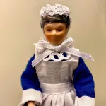 Dukke ældre stuepige, Dukke i blå kjole og forklæde, barneplejerske, barnepige, hushjælp, stuepige, køkkenhjælp, Baby hvid, Baby rosa, babydukke, dukkebaby, dukkehusdukke, dukkehusbaby, mini, miniatyre, miniature, lille, lyserød, rosa, pink, ting til dukkehuset, miniaturen, dollhouse, biti, ribe, vadehavet,