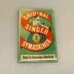 Miniature Emalje skilt - Singer, skrædder, skrædderi, systue, syerske, syning, Miniature Emalje skilte, reklameskilte, butiksskilte, butiksreklame, emaljeskilt, emaljeskilte, gamle, dukkehus, købmandsbutik, miniature, mini, dukkebutik, købmand, høker, landhandel, 1:12, biti, ribe