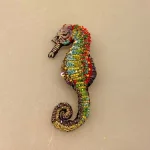 Håndlavet Broche Søhest, sea horse, havdyr, havfrue, stranden, havet, hav, biolog, smykke, unika, perlebroderi, havet, stranden, beach, sea, havets brusen, krebs, skaldyr, gyldne farver, coral, koral, koraller, håb, gaveide, gave, broche, nål, pynt, til strik, på hat, på hue, reversnål, biti, ribe, vadehavet, nationalpark, boredri, broderibe, pailletter,