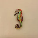 Håndlavet Broche Søhest, sea horse, havdyr, havfrue, stranden, havet, hav, biolog, smykke, unika, perlebroderi, havet, stranden, beach, sea, havets brusen, krebs, skaldyr, gyldne farver, coral, koral, koraller, håb, gaveide, gave, broche, nål, pynt, til strik, på hat, på hue, reversnål, biti, ribe, vadehavet, nationalpark, boredri, broderibe, pailletter,
