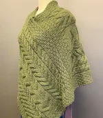 Aran Poncho i Merinould - Grøn, olivengrøn, varm, gulgrøn, b676, 430, irsk, aran, mønster, kabel, strik, håndstrikket, poncho, ren, uld, lambswool, merino, uldponcho, praktisk, smart, lækker, lun, blød, vissengrøn, Aran Poncho i merinould - Lysegrå, poncho, cape, kappe, slag, stola, skuldervarmer, gaveide, ældre, smart, håndstrikket, blød, varm, tørklæde, over skuldrene, aran, irsk, kabelstrik, kabelstrikket, ung, unge, piger, kvinder, damer, julegave, ide, overtøj, fryser, lun, klædelig, praktisk, kørestol, holde varmen, aranstrik, biti, ribe, dansk, design, super, fin, praktisk, flyveren, indenfor, terrassen,