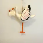 Ophæng - Stork i Filtet Uld, filtophæng, filtstork, stork, baby, kommer, med, børnene, storken, barsel, nyfødt, lille ny, barselsgave, barselsstork, vikle, baby, shower, dåbsgave, tillykke, nyfødt, forældre, symbolsk, gave, ribe, storkenes by, biti, håndlavet, sød, fin, odevaar, SMV, sjaal met verhaal, nepal, fairtrade, pynt, dekoration, uld,