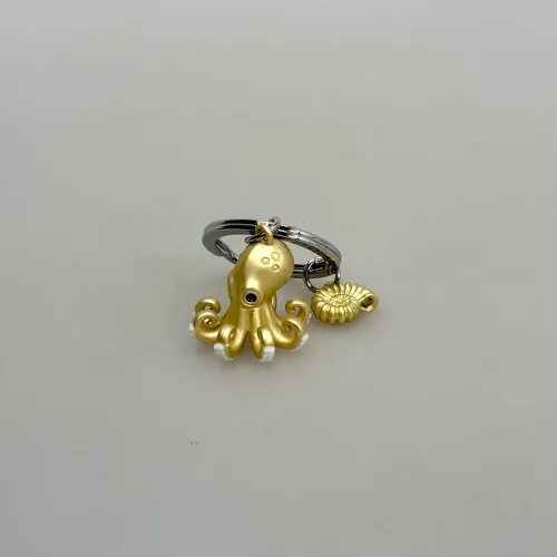 Nøglering Gylden Blæksprutte og Sneglehus, octopus, blæksprutte, havet, havdyr, ocean, ottearmet, havbiolog, marinebiolog, marine, symbolsk, biologi, biolog, nature, nytting, lækker,særlig, symbolsk, akvarium, blå planet, biti, ribe